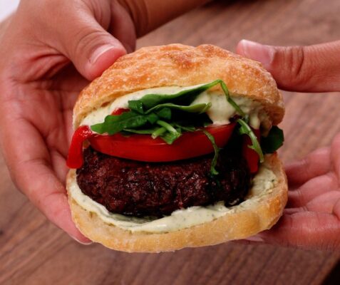 a hand holding a burger
