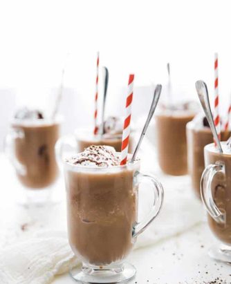 Add the coffee, ice, oat milk and chocolate sauce to a blender and blend on high speed until smooth. Distribute the Frozen Mochas between 6 glasses and top off with CocoWhip, chocolate sauce for garnish and shaved chocolate.
