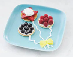 Eggo Pancakes decorated with fruit and icing to look like balloons on a plate