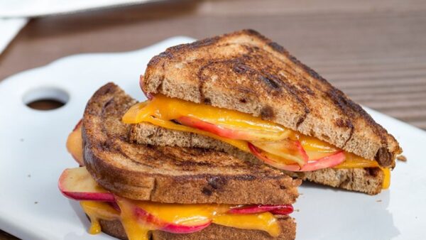 a sliced apple pie grilled cheese sandwich on a white plate