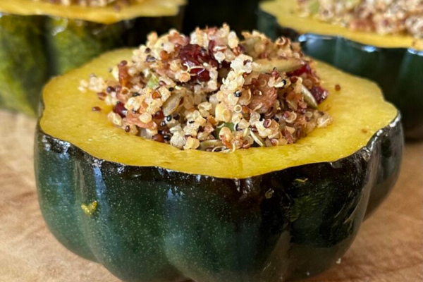 half of an acorn squash cut into a bowl with grains inside