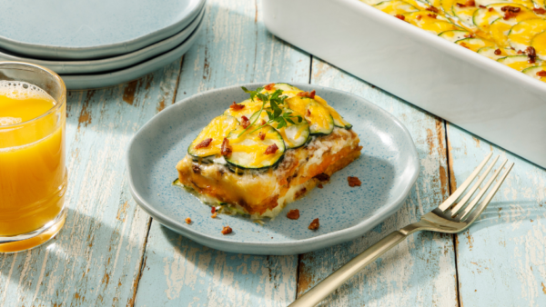 BACON CHEDDAR SCALLOPED ZUCCHINI on a plate next to a fork