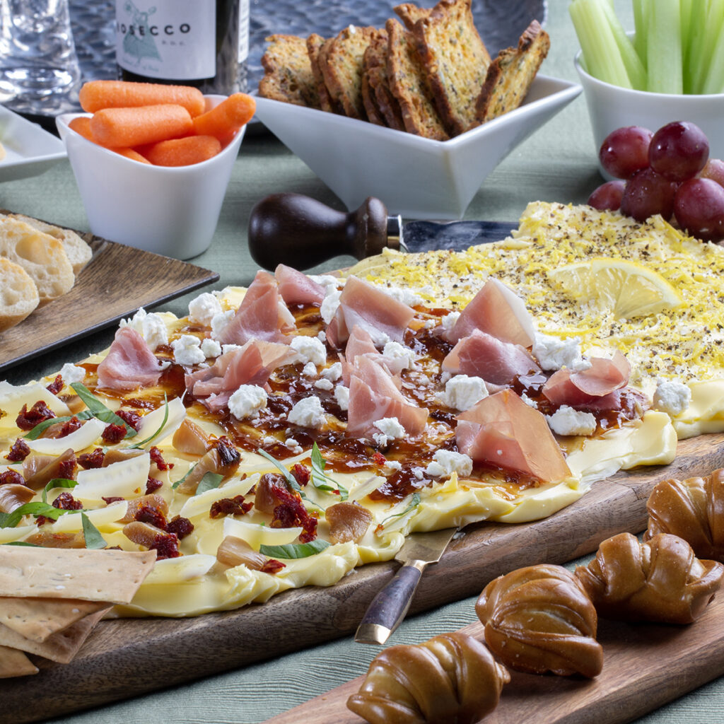 Wooden cutting board spread with butter topped with various toppings.