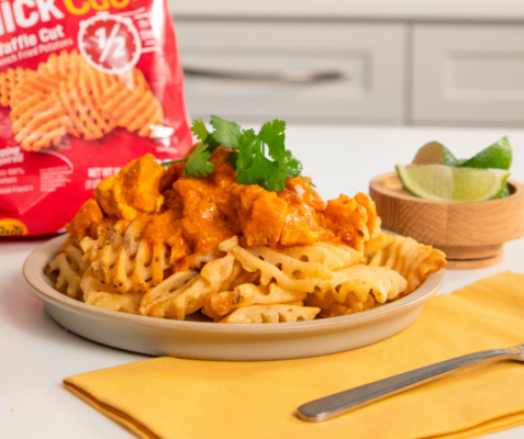 Plate of fries with butter chicken on top