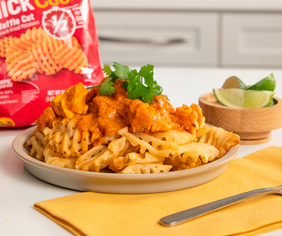 Plate of fries with butter chicken on top