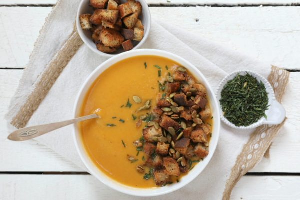 Bowl of soup, cup of herbs, and a cup of croutons