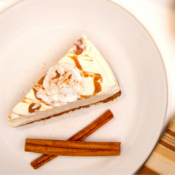 Cheesecake and 2 cinnamon sticks on a plate