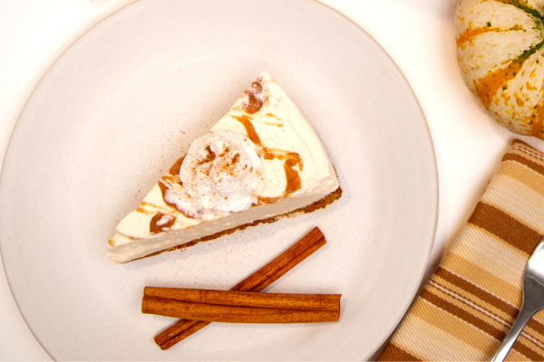 Cheesecake and 2 cinnamon sticks on a plate