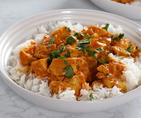 White bowl filled with jasmine rice and chicken tikka masala