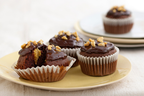 Close up shot of a plate with 3 chocolate-peanut butter cupcakes