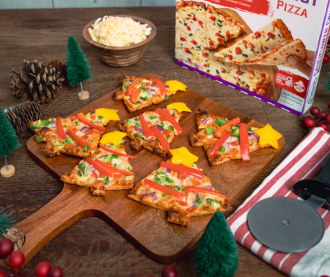 Mini Christmas tree shaped pizza slices on a wooden cutting board