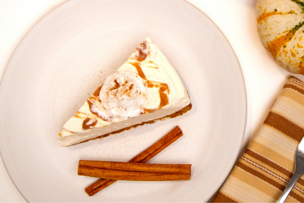 a slice of pie and two cinnamon sticks on a plate