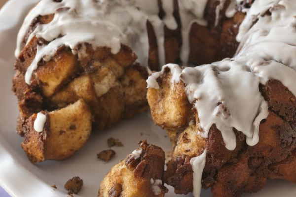 Close up image of cinnamon pecan pull apart bread with one slice missing