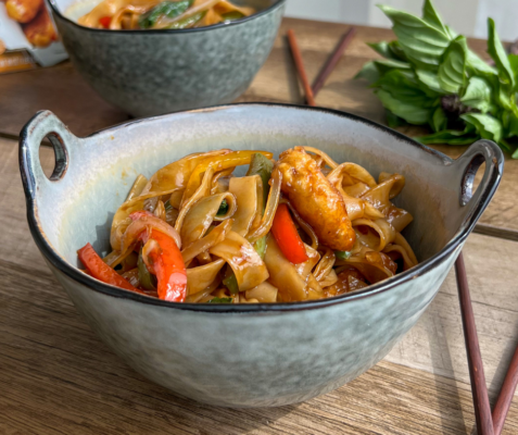 A bowl filled with crispy chicken drunken noodles