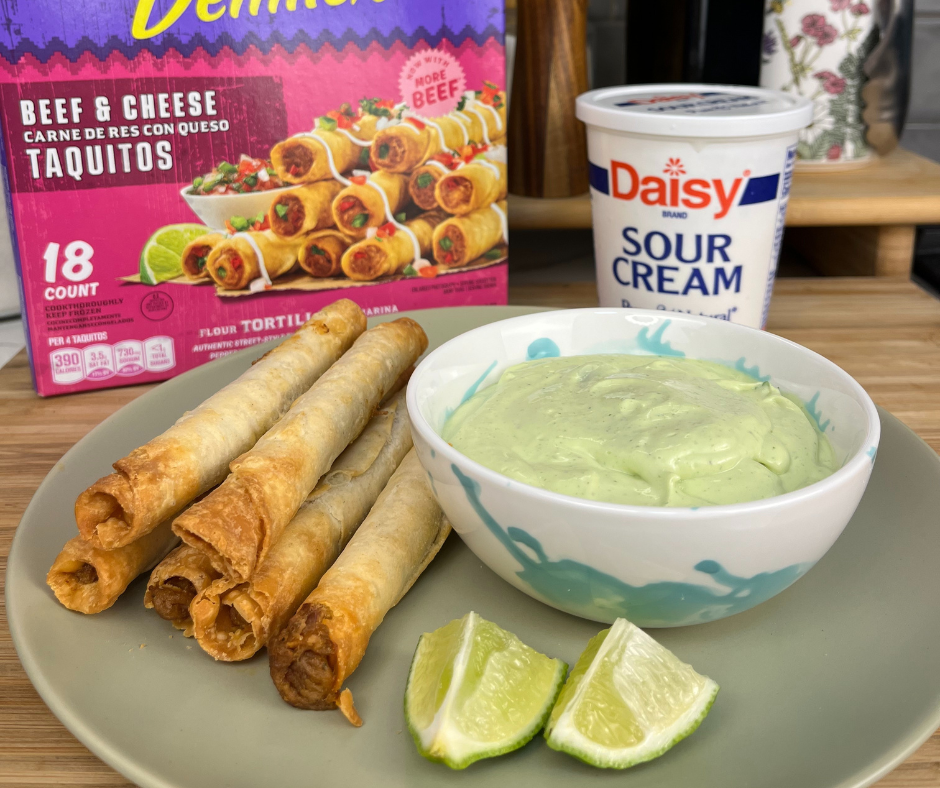 Rolled tacos on a plate next to a bowl of green dipping sauce