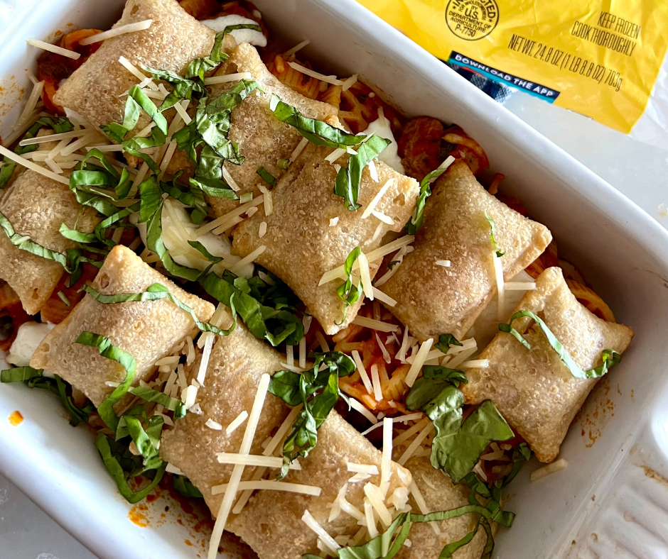White baking dish filled with pizza rolls topped with basil and cheese