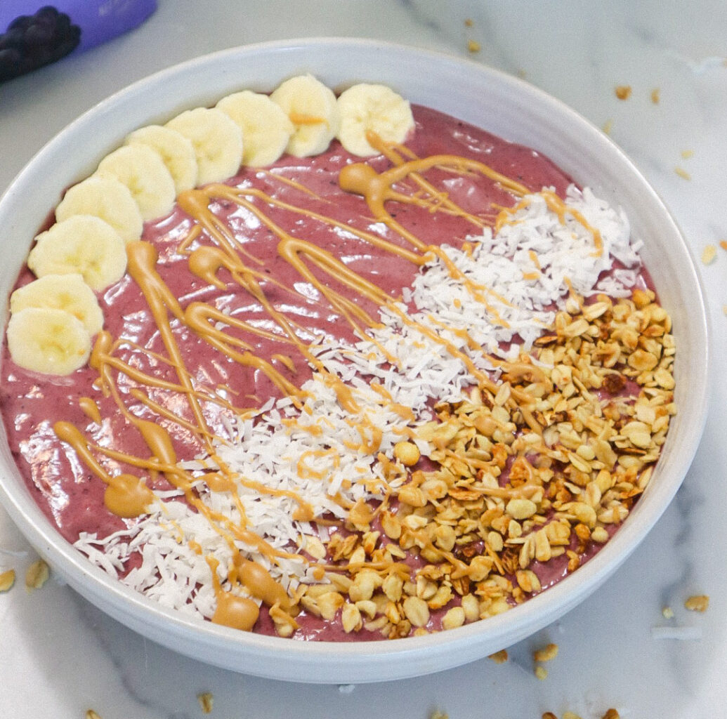 Overhead view of a smoothie bowl with various toppings in a white bowl