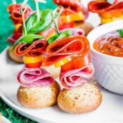 meat and peppers on a skewer on a white plate