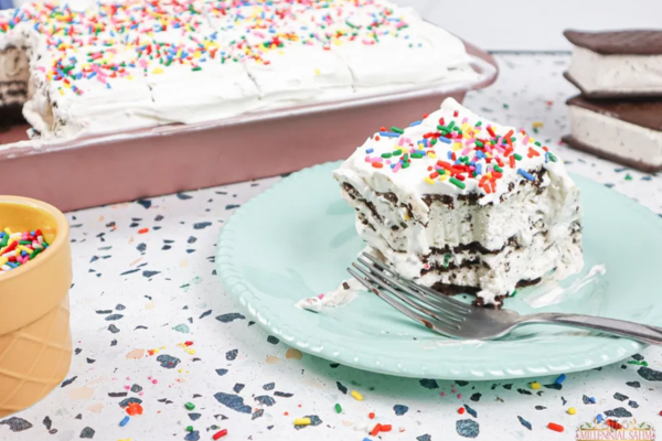 a slice of bitten ice cream cake next to a fork on a blue plate