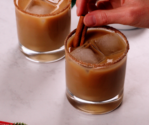 A glass of gingerbread eggnog white Russian garnished with a cinnamon stick