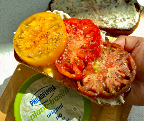 Tomatoes on a piece of bread being held by a hand