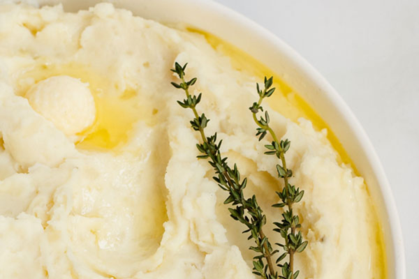 Mashed potatoes topped with two sprigs of herbs