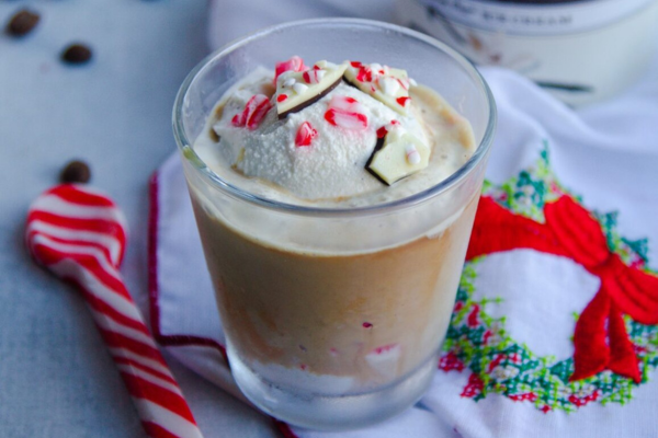 a glass filled with coffee topped with whipped cream and peppermint flakes
