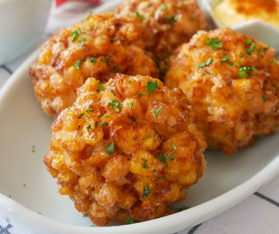 Close up shot of four Korean corn cheese balls on a white plate