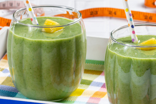 Two glasses filled with green smoothies