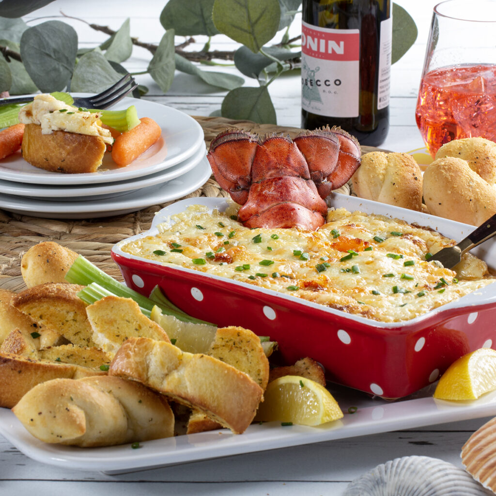 Lobster Roll Dip in a red baking dish surrounded by breadsticks