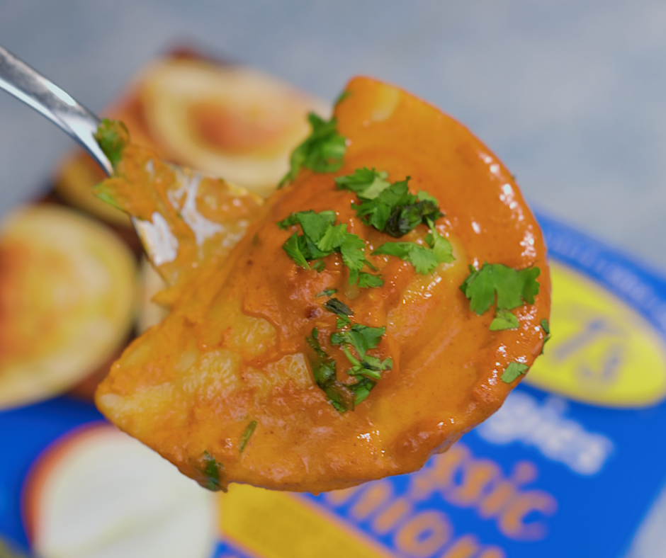 Close up shot of a sauce covered pierogi on a fork