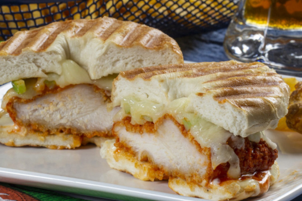 fried chicken and cheese on a bagel that is cut in half