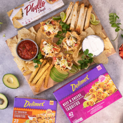 Cinco de Mayo Party platter with two boxes of Delimex Taquitos next to it and one box of athen's phyllo dough