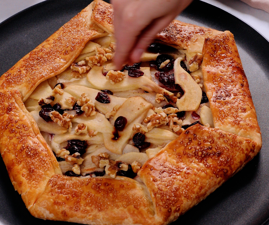 A galette being sprinkled with spices