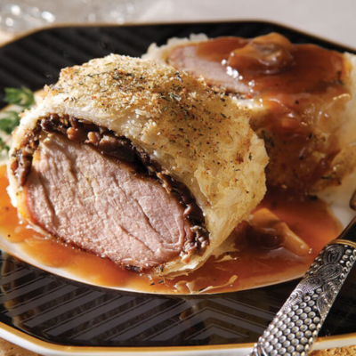 a slice of pork tenderloin wrapped in phyllo that is sitting on a plate