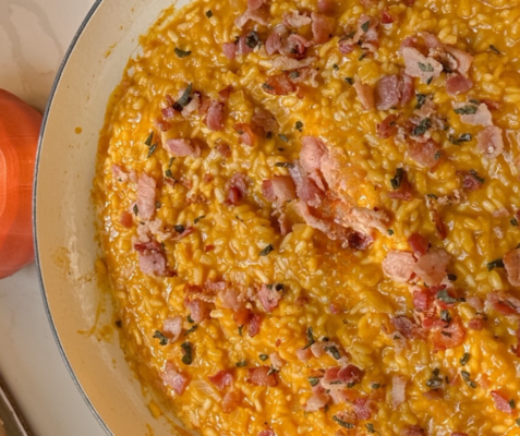 bowl of orange risotto with bacon