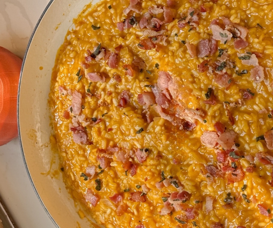 bowl of orange risotto with bacon