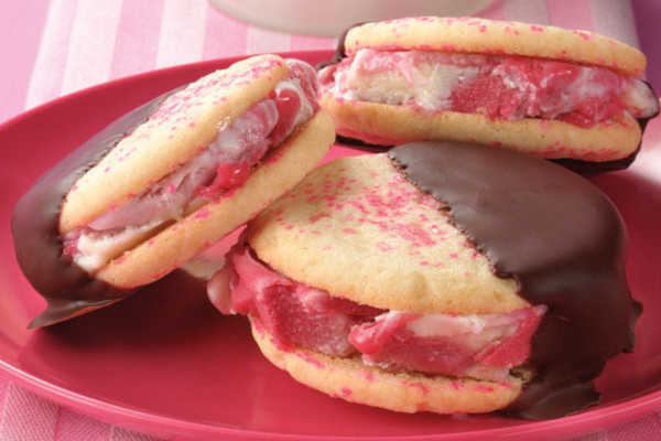 Pink plate with 3 stacked ice cream sandwiches with pink sprinkles on top