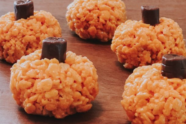 Mini pumpkins made with orange rice crispies and a tootsie roll stem