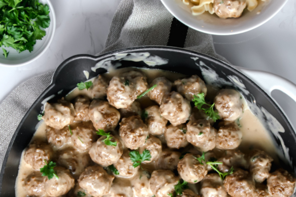 close up image of half of a skillet filled with swedish meatballs