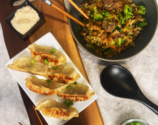 overhead shot of dumplings on a plate and beef broccoli in a bowl