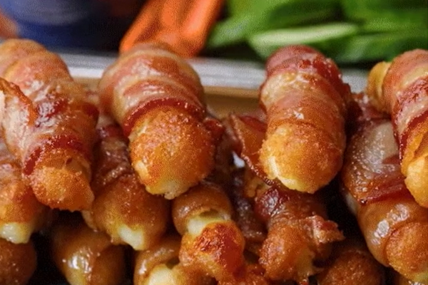 Tasty Sweet and Spicy Bacon Wrapped Mozzarella Sticks Stacked on top of each other