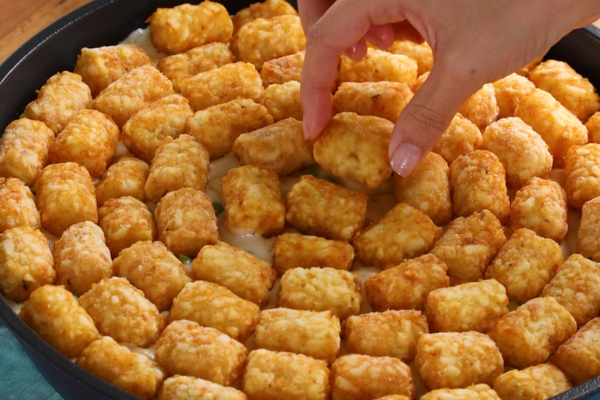 Tater tots neatly placed in a cooking skillet