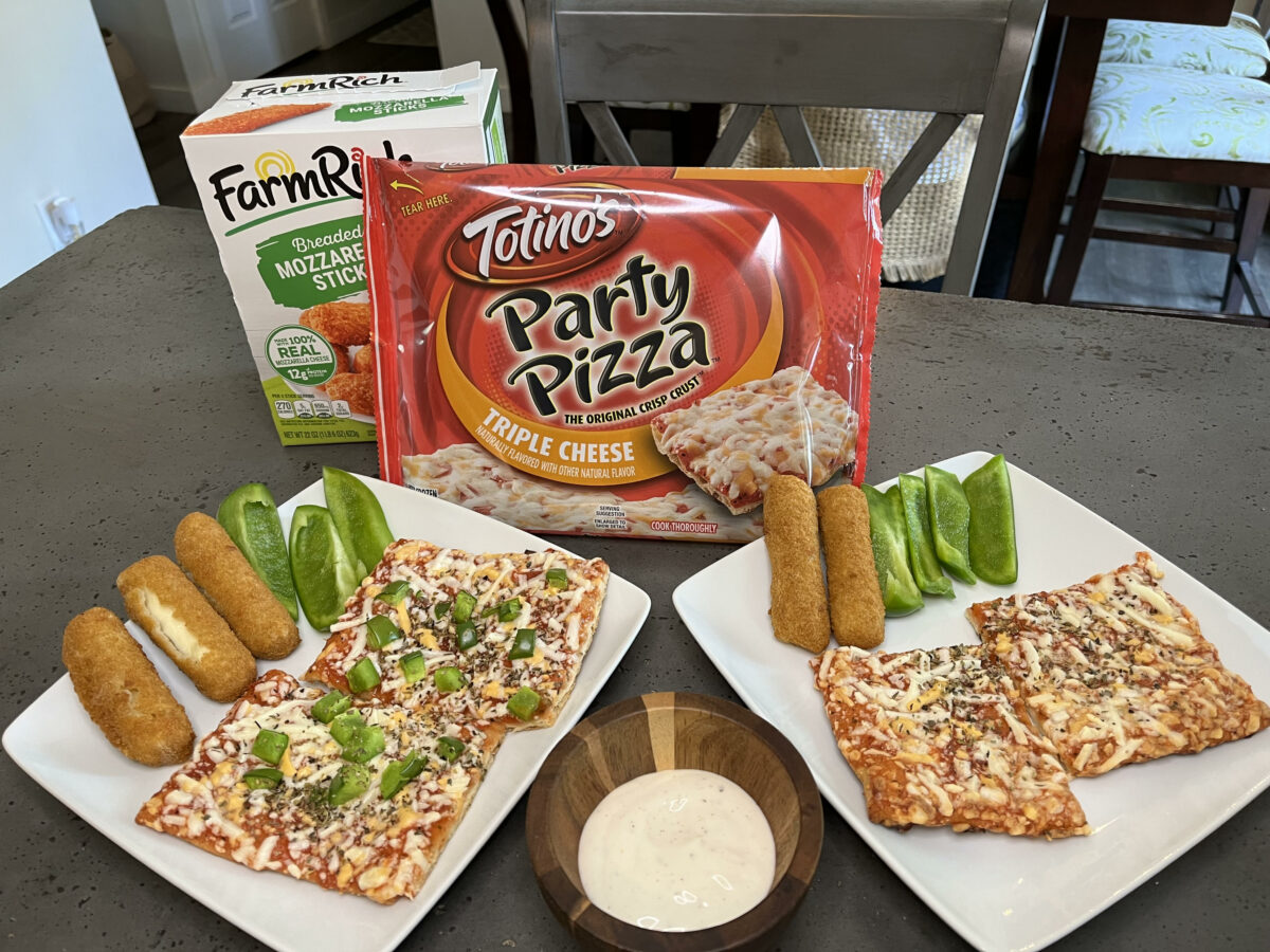 Two plates with pizza, green peppers, and mozzarella sticks