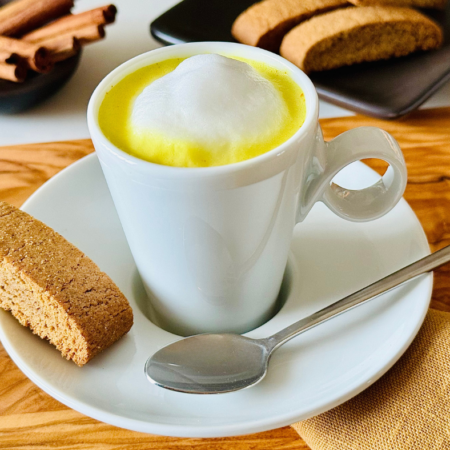 turmeric latte inside a white mug on a plate