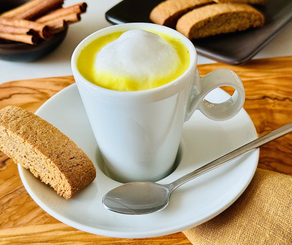 turmeric latte inside a white mug on a plate