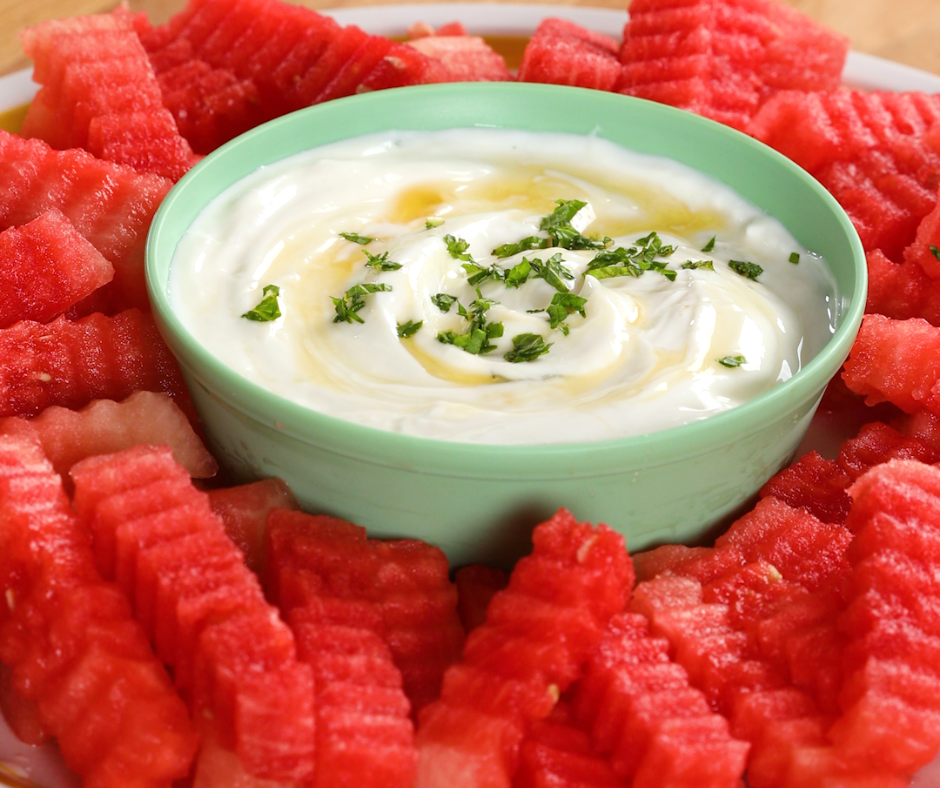 Watermelon cut into a crinkle cut fry shape and a bowl filled with dip in the middle