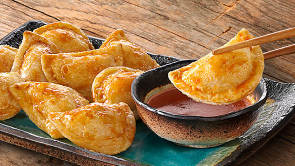 SWEET AND SPICY SRIRACHA MINI PIEROGIES on a dish with a bowl of sauce