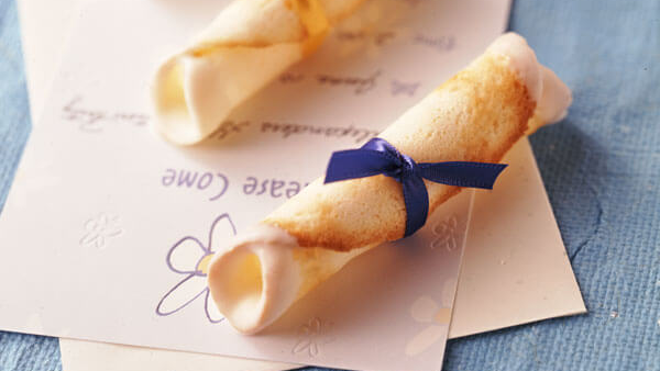 Diploma cookies wrapped in blue ribbon sitting on a spring themed card