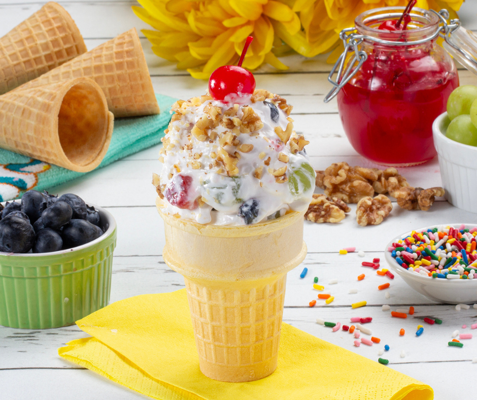 ice cream cone filled with frozen yogurt surrounded by various ice cream toppings